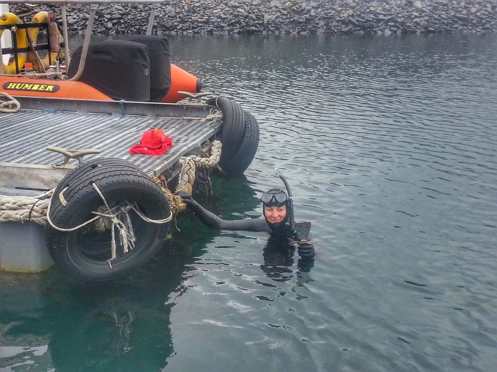 Claire de-weeding underneath the pontoon.